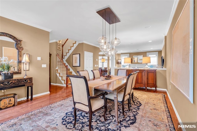 dining space with crown molding and light hardwood / wood-style flooring