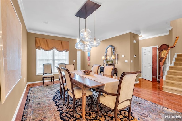 dining space with crown molding and hardwood / wood-style flooring