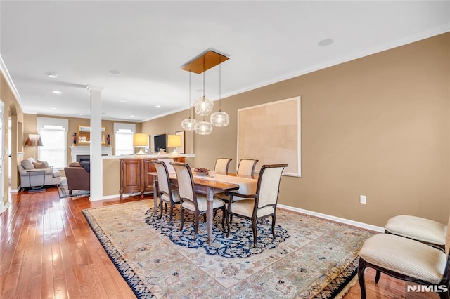 dining space with crown molding and light hardwood / wood-style flooring