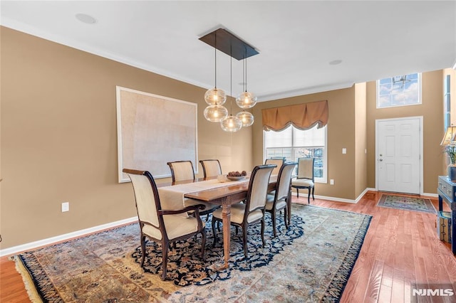 dining area with ornamental molding and hardwood / wood-style floors