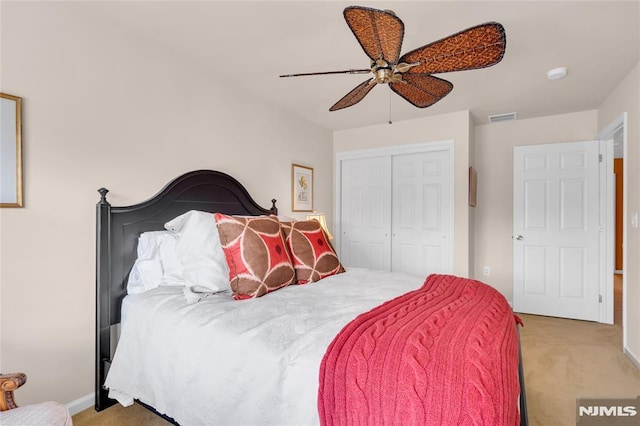 carpeted bedroom with ceiling fan and a closet