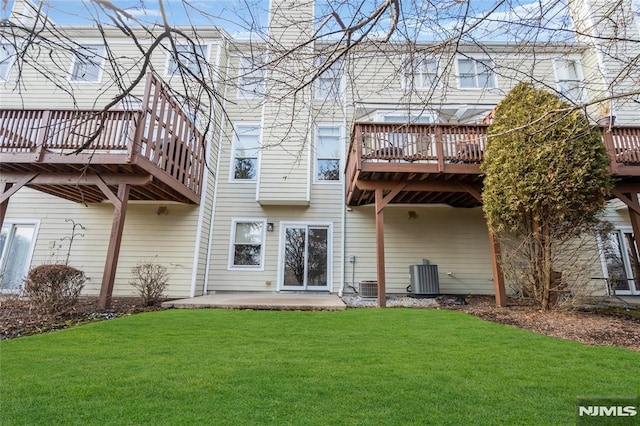 rear view of house featuring a wooden deck, a lawn, and central air condition unit