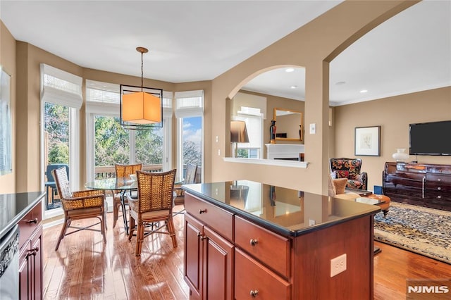 kitchen with light wood-type flooring, pendant lighting, dishwasher, and a center island