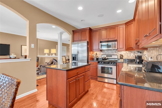 kitchen with light hardwood / wood-style floors, sink, appliances with stainless steel finishes, and a kitchen island