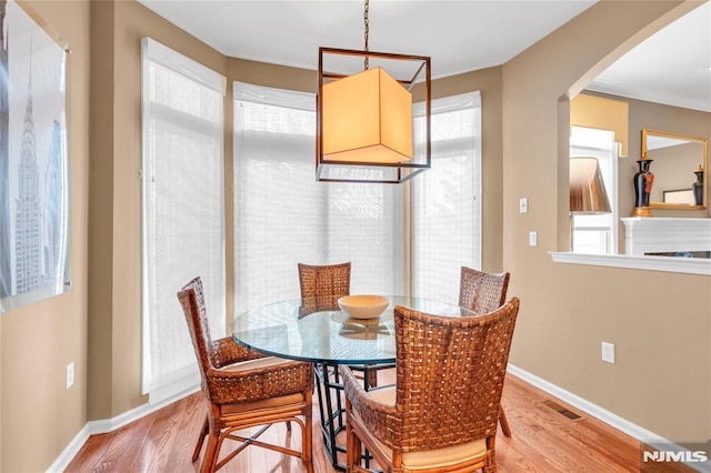 dining room featuring a wealth of natural light, ornamental molding, and hardwood / wood-style flooring