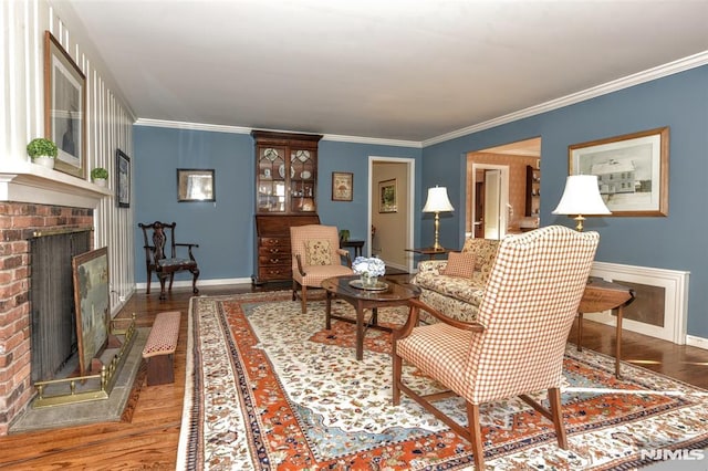 living room with a brick fireplace, ornamental molding, and hardwood / wood-style flooring