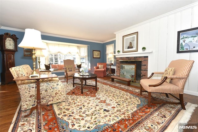 living area with a brick fireplace, crown molding, and hardwood / wood-style floors