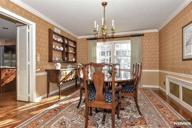 dining space featuring ornamental molding, dark hardwood / wood-style flooring, and a chandelier