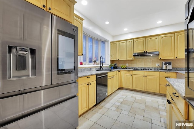 kitchen featuring black appliances, light stone counters, light brown cabinetry, and sink