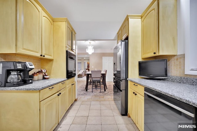 kitchen featuring stainless steel fridge, light tile patterned floors, decorative backsplash, and black oven