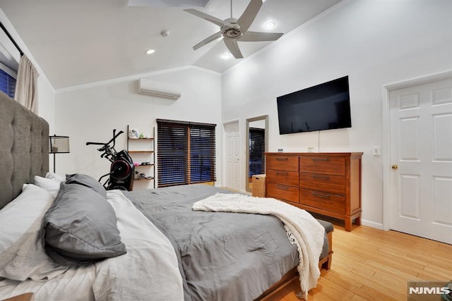 bedroom featuring a wall mounted air conditioner, light hardwood / wood-style flooring, vaulted ceiling, and ceiling fan