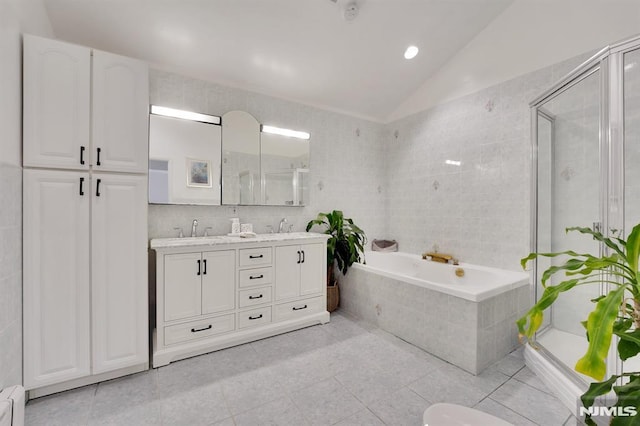 bathroom with independent shower and bath, vaulted ceiling, and tile patterned flooring