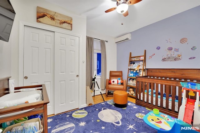 bedroom with a wall mounted AC, a closet, and ceiling fan