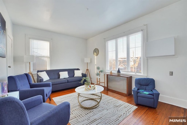 living room with plenty of natural light, wood-type flooring, and radiator heating unit