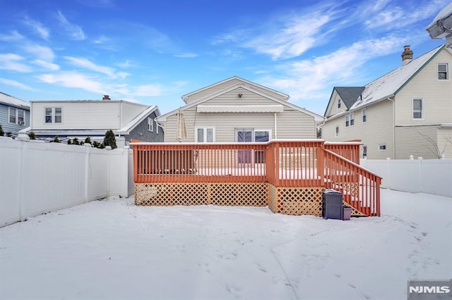 snow covered rear of property featuring a deck