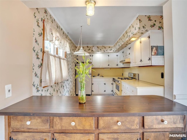 kitchen with stainless steel refrigerator, white gas stove, hanging light fixtures, crown molding, and white cabinets