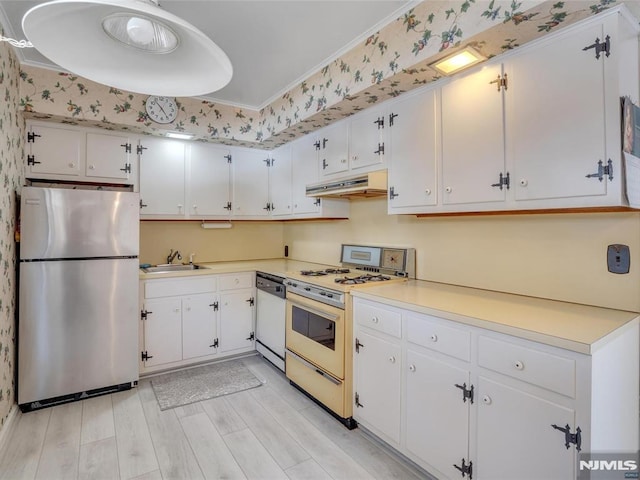 kitchen featuring stainless steel refrigerator, sink, dishwashing machine, white cabinets, and white gas range oven