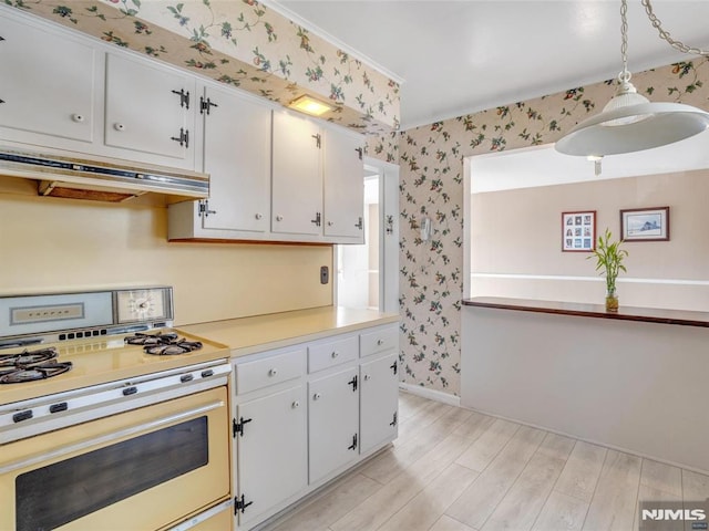 kitchen with range with gas stovetop, decorative light fixtures, white cabinetry, and light hardwood / wood-style flooring