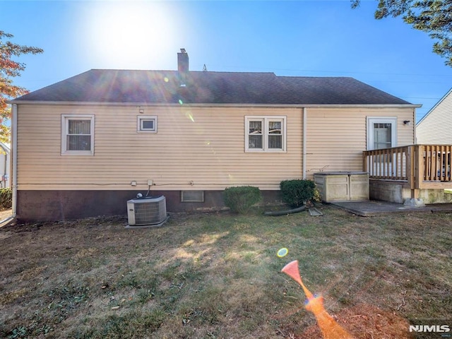 rear view of house featuring a lawn, central AC, and a deck