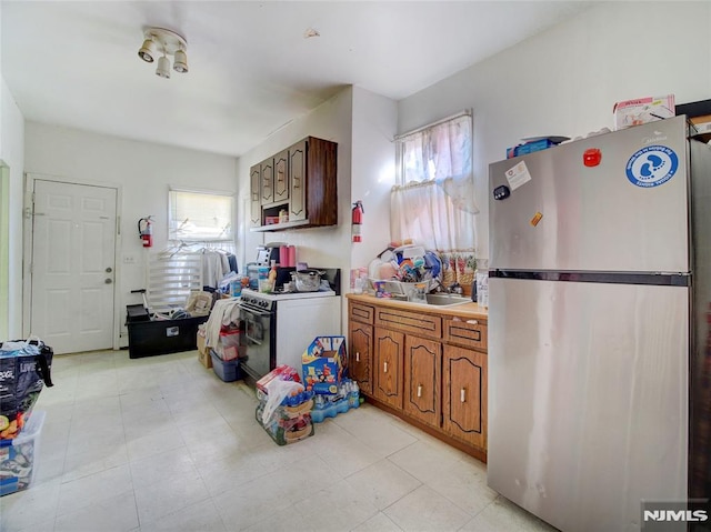 kitchen with gas range, stainless steel refrigerator, and sink