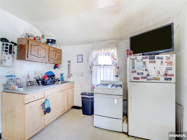 kitchen with white appliances, sink, and vaulted ceiling