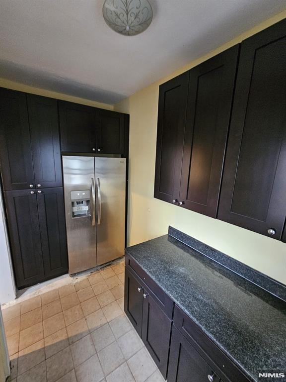 kitchen with light tile patterned floors and stainless steel fridge with ice dispenser