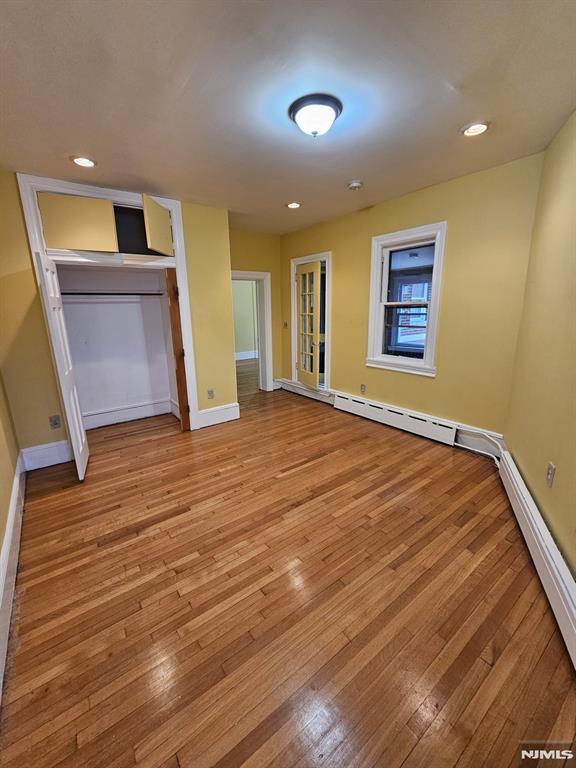 interior space featuring baseboard heating and light wood-type flooring