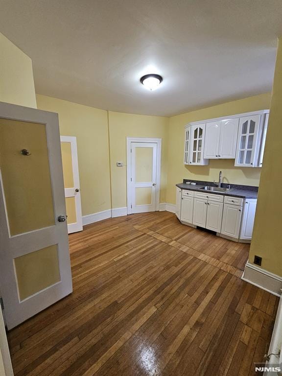 kitchen with white cabinets, dark hardwood / wood-style flooring, and sink