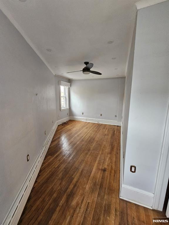 empty room with hardwood / wood-style flooring, a baseboard heating unit, and ceiling fan