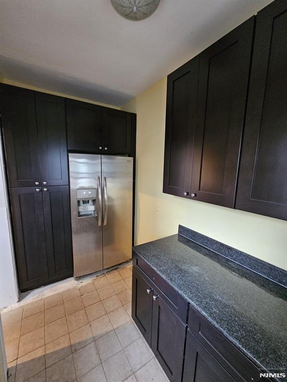 kitchen with light tile patterned floors and stainless steel refrigerator with ice dispenser