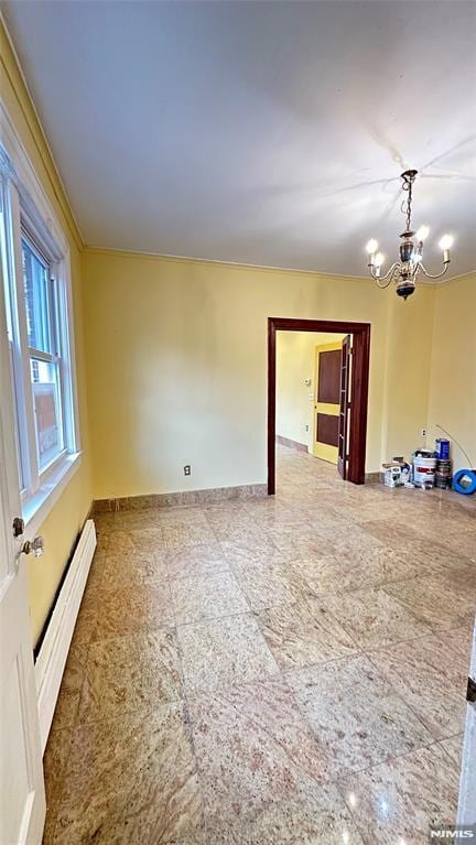 spare room with a baseboard heating unit and an inviting chandelier