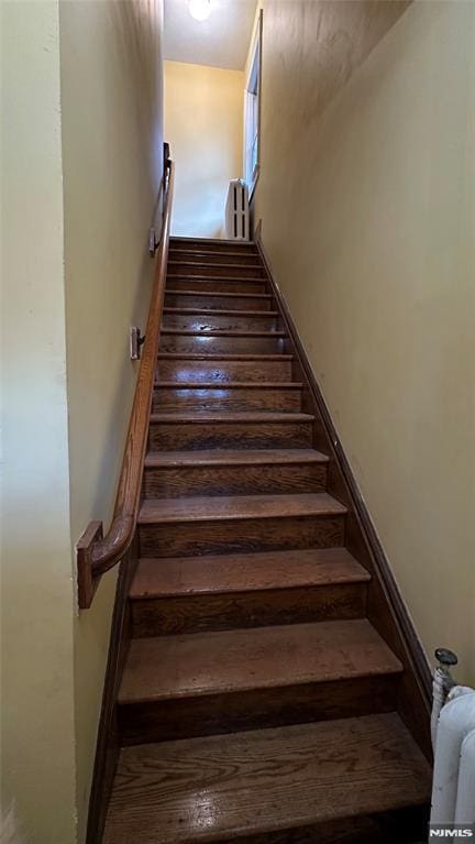 stairway featuring radiator heating unit