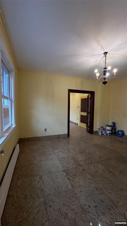 unfurnished room with an inviting chandelier and a baseboard heating unit