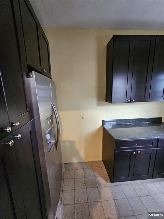 kitchen featuring stainless steel refrigerator with ice dispenser and light tile patterned floors