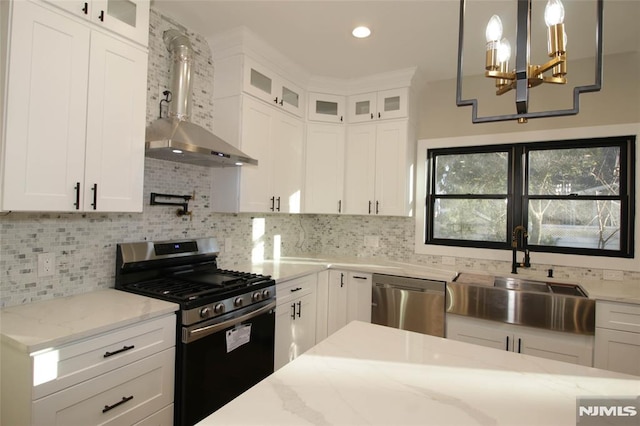 kitchen with tasteful backsplash, white cabinetry, decorative light fixtures, and appliances with stainless steel finishes