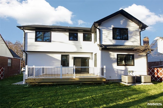 rear view of property featuring a yard and central air condition unit