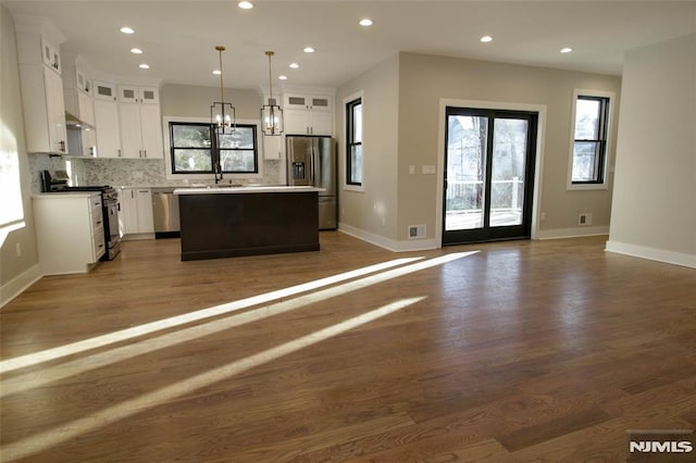 kitchen featuring white cabinetry, a center island, dark hardwood / wood-style floors, pendant lighting, and appliances with stainless steel finishes