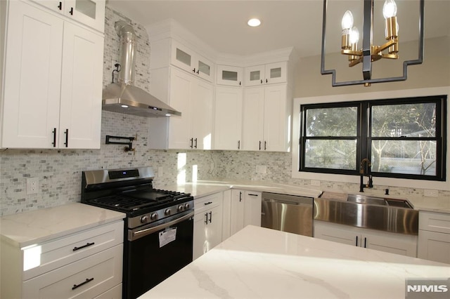 kitchen with decorative backsplash, white cabinetry, hanging light fixtures, and appliances with stainless steel finishes