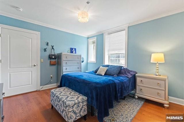 bedroom with crown molding and hardwood / wood-style flooring