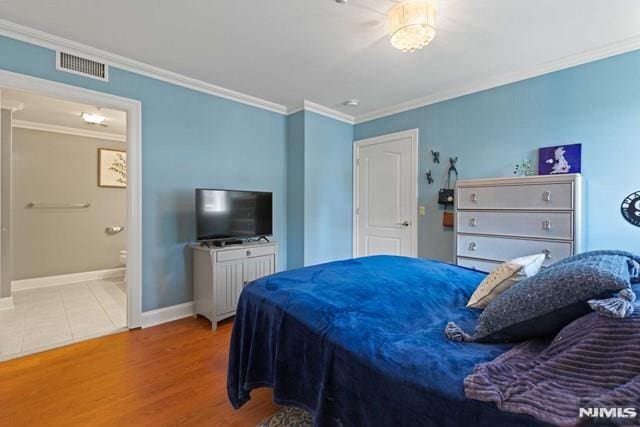 bedroom with ensuite bathroom, crown molding, and hardwood / wood-style floors