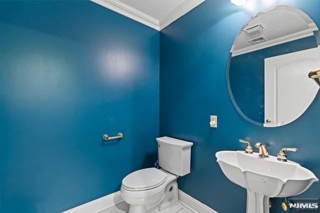 bathroom featuring ornamental molding, tile patterned floors, sink, and toilet