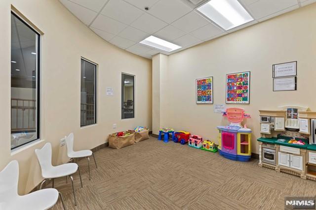 rec room with a paneled ceiling and carpet