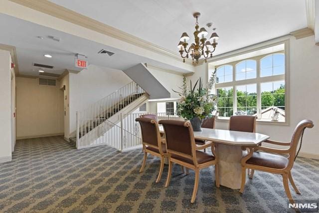 dining room featuring ornamental molding, a notable chandelier, and dark carpet