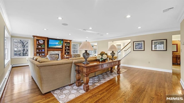 living room featuring a baseboard heating unit, ornamental molding, and light hardwood / wood-style flooring