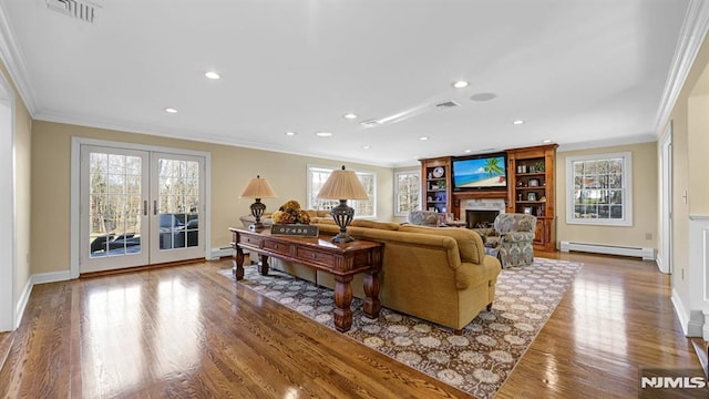 living room featuring ornamental molding, french doors, hardwood / wood-style flooring, and a baseboard heating unit