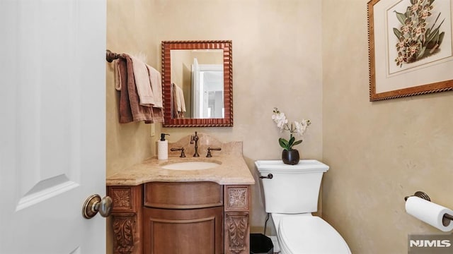 bathroom featuring toilet and vanity