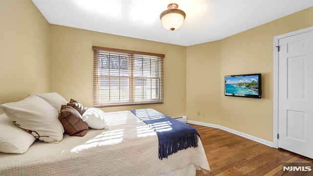 bedroom featuring a baseboard radiator and hardwood / wood-style floors