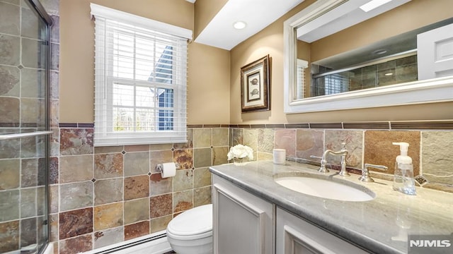 bathroom with tile walls, walk in shower, vanity, and toilet