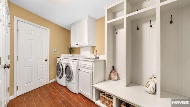 clothes washing area with cabinets, separate washer and dryer, and sink