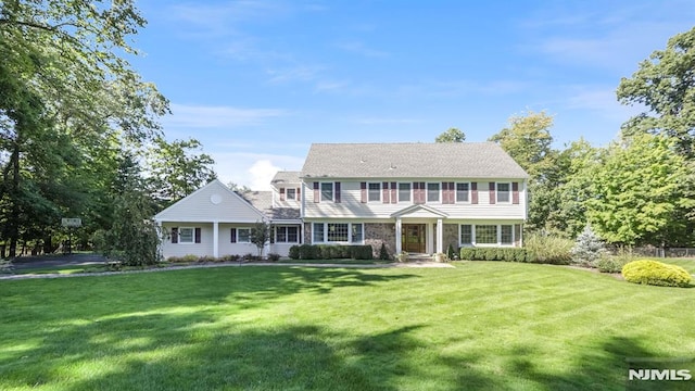 colonial inspired home featuring a front lawn